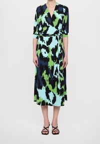 Šaty s zavinovacím designem v mnohobarevném abstraktním vzoru obsahujícím odstíny modré, zelené a černé. Vyrobeno z lehkého materiálu, délka po střed lýtek.