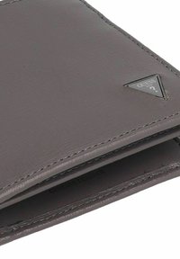 Billetera de cuero gris con superficie texturizada, que presenta un logotipo triangular en negro y gris, bordes cosidos y un forro interior suave.