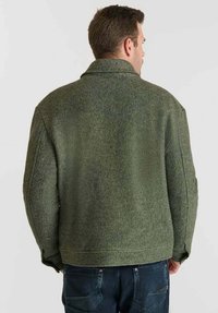 Chaqueta texturada en verde oliva con un cuello ancho, hombros caídos y un corte relajado, que presenta un acabado suave y sin herrajes visibles.
