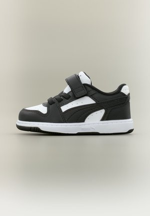 Schwarz-weißer Kleinkind-Sneaker mit Klettverschluss und Schnürsenkeln, weißer Sohle und strukturierten schwarzen Obermaterialdetails, Seitenansicht auf neutralem Hintergrund.
