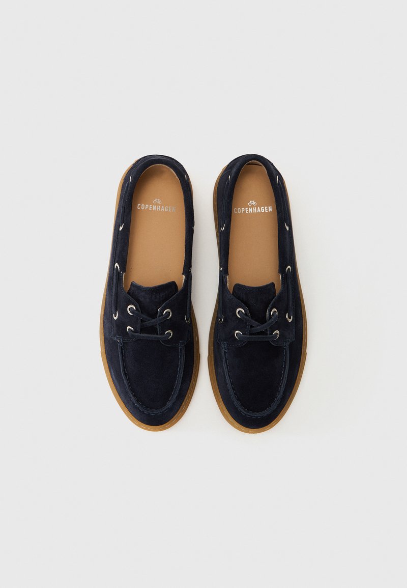 Marineblaue Wildlederschuhe mit runder Spitze, Lederhälsen und einer sandfarbenen Gummi-Außensohle. Mit flinke Details und einem Logo auf der Innensohle.