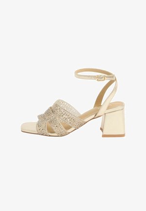 Gold block-heeled sandal with ankle strap and sparkling rhinestone-embellished crisscross straps over open toe.