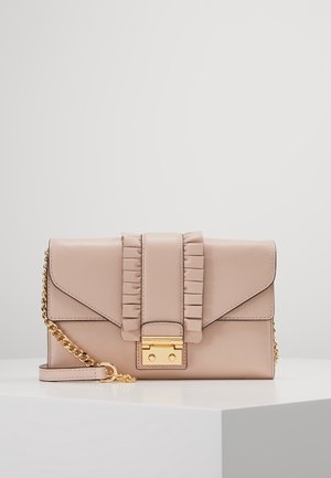 Pochette rectangulaire en cuir beige clair avec détail de la sangle froncée et bandoulière chaîne dorée, posée sur une surface blanche avec un fond uni.