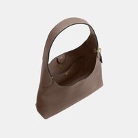 Sac à main en cuir marron avec une sangle large unique, ouverture supérieure et poche intérieure sécurisée par deux boutons-pression.