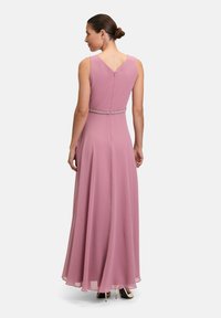 Langroze jurk met een vloeiende silhouet, met een v-rug, versierde tailleband en zonder mouwen. Gladde stoftextuur.