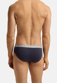 Marineblauem Slip mit einem hellgrauen Bund, der das Logo "HANRO" zeigt, aus glattem Stoff gefertigt, bietet eine figurbetonte und minimalistische Design.