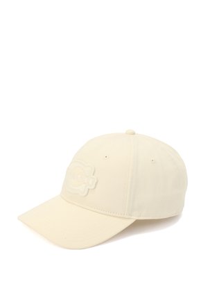 Cream-colored cap made of fabric with a structured design. Features an embroidered logo patch on the front and a curved brim.