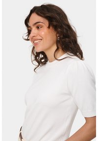 Top bianco a maniche corte con scollatura rotonda, texture a costine e dettagli a maniche a sbuffo, progettato per una silhouette aderente.
