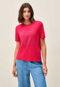 Rød bomulds T-shirt med et kvadratisk grafik med et mønstret design og ordet "Santorini" nederst. Korte ærmer, afslappet pasform.