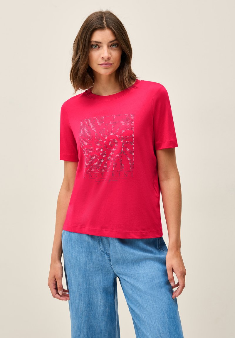Rød bomulds T-shirt med et kvadratisk grafik med et mønstret design og ordet "Santorini" nederst. Korte ærmer, afslappet pasform.