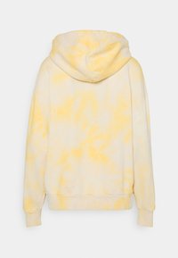 Felpa gialla tie-dye con una texture morbida, grande cappuccio e polsini e orlo a costine. Presenta una vestibilità oversize con un design casual sul retro.