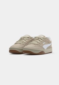 Gai smilšu krāsas zamšsneakers ar baltu sānu līniju, apaļu purngaliem, saistāmu dizainu un teksturētu gumijas zoli ar nelielu platformu.