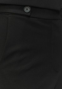 Czarne eleganckie spodnie z gładkiego materiału, z zapięciem na guzik, kieszeniami po bokach oraz subtelnym wzorem tekstury.