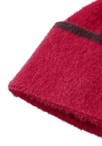 Tessuto a maglia rosso con una consistenza pelosa, caratterizzato da una striscia orizzontale marrone scuro vicino al bordo superiore. Forma rettangolare con una finitura morbida.