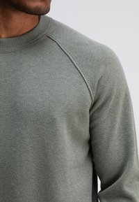 Grau Sweatshirt aus weichem Stoff, mit Rundhalsausschnitt und Raglanärmeln, verfügt über eine glatte Textur ohne sichtbare Muster oder Akzente.