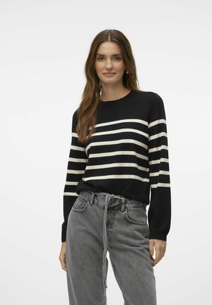 Schwarz-weißer gestreifter Pullover mit rundem Ausschnitt und langen Ärmeln, kombiniert mit hoch taillierten grauen Denim-Hosen. Weicher Stoff, lässiges Design.