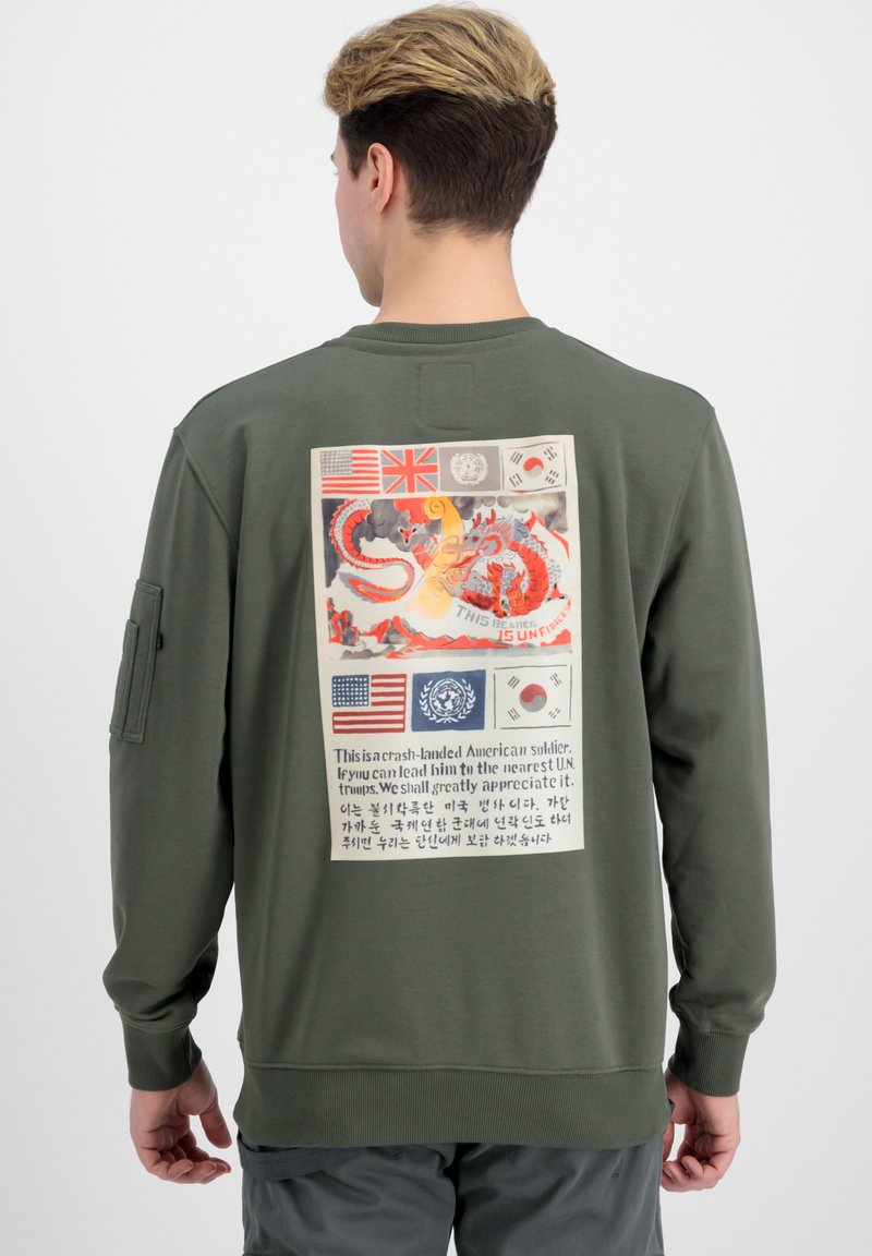 Sudadera de color verde oliva con un gráfico en la parte posterior que incluye banderas, texto e ilustración de un dragón rojo. Puños y dobladillo acanalados.