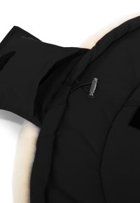 Zwarte stof met een gladde textuur, voorzien van een zachte, crèmekleurige voering, verstelbare trekkoord en klittenbandsluitingen.