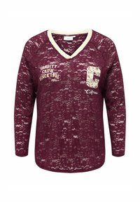 Haut en dentelle bordeaux à manches longues avec encolure en V, bordure blanc-jaune et texte imprimé "Varsity Crew Since 1991" et "California" avec une grande lettre C.