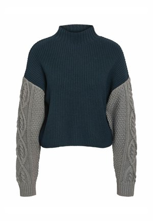Jersey de punto grueso con cuello alto, con un cuerpo azul oscuro y mangas de punto cableado color gris claro, que destacan la textura y los colores en contraste.