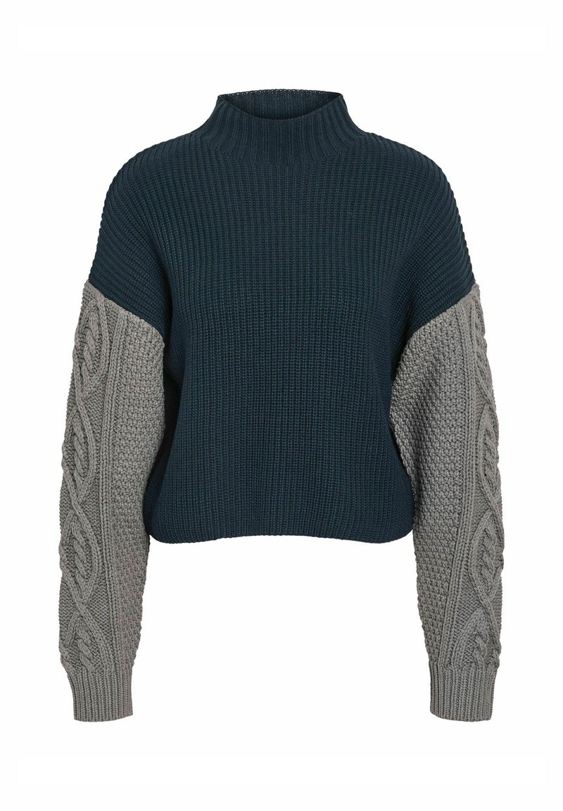 Pull en tricot épais avec un col haut, présentant un corps bleu foncé et des manches en tricot torsadé gris clair, mettant en valeur la texture et les couleurs contrastées.