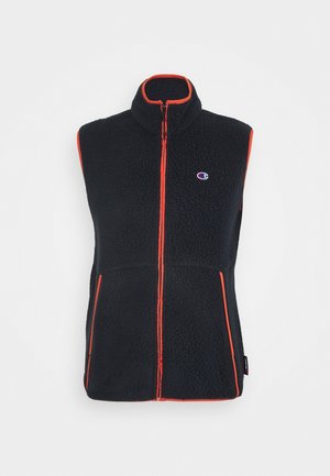 Gilet sans manches en polaire noire avec passepoil orange, fermeture éclair à l'avant, deux poches et un petit logo Champion sur la poitrine.