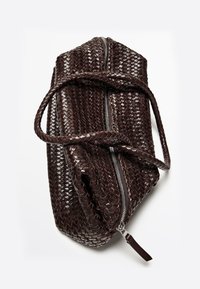 Sac en cuir tressé marron foncé avec une fermeture zip et une seule poignée tressée, présentant une surface texturée et une forme incurvée.