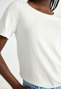 T-shirt bianco a maniche corte realizzata in cotone morbido. Collo rotondo e vestibilità casual, con dettagli di cucitura in vista e leggera texture.