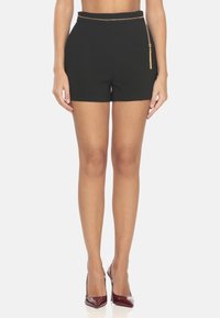 Pantaloni corti neri strutturati con vita alta e un accentuato in catena dorata sul lato. Realizzati in tessuto liscio, presentano una vestibilità sartoriale.