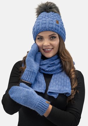 Berretto lavorato a maglia blu con pon-pon in pelliccia sintetica, guanti coordinati e sciarpa. Il tessuto testurizzato presenta un design a coste e a trecce.