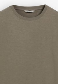 Khaki-colored crew neck t-shirt with subtle "SCALPERS" logo embroidered on the left chest and regular fit label inside collar.