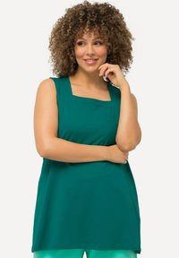 Tunic top senza maniche turchese con scollatura quadrata, tessuto morbido e vestibilità comoda, indossato con pantaloni verde chiaro.