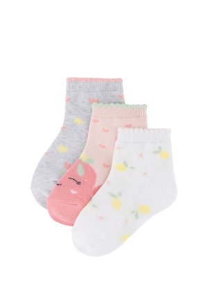 Tres pares de calcetines para bebé en colores pastel: gris con corazones, rosa con una cara sonriente de manzana y blanco con limones amarillos.