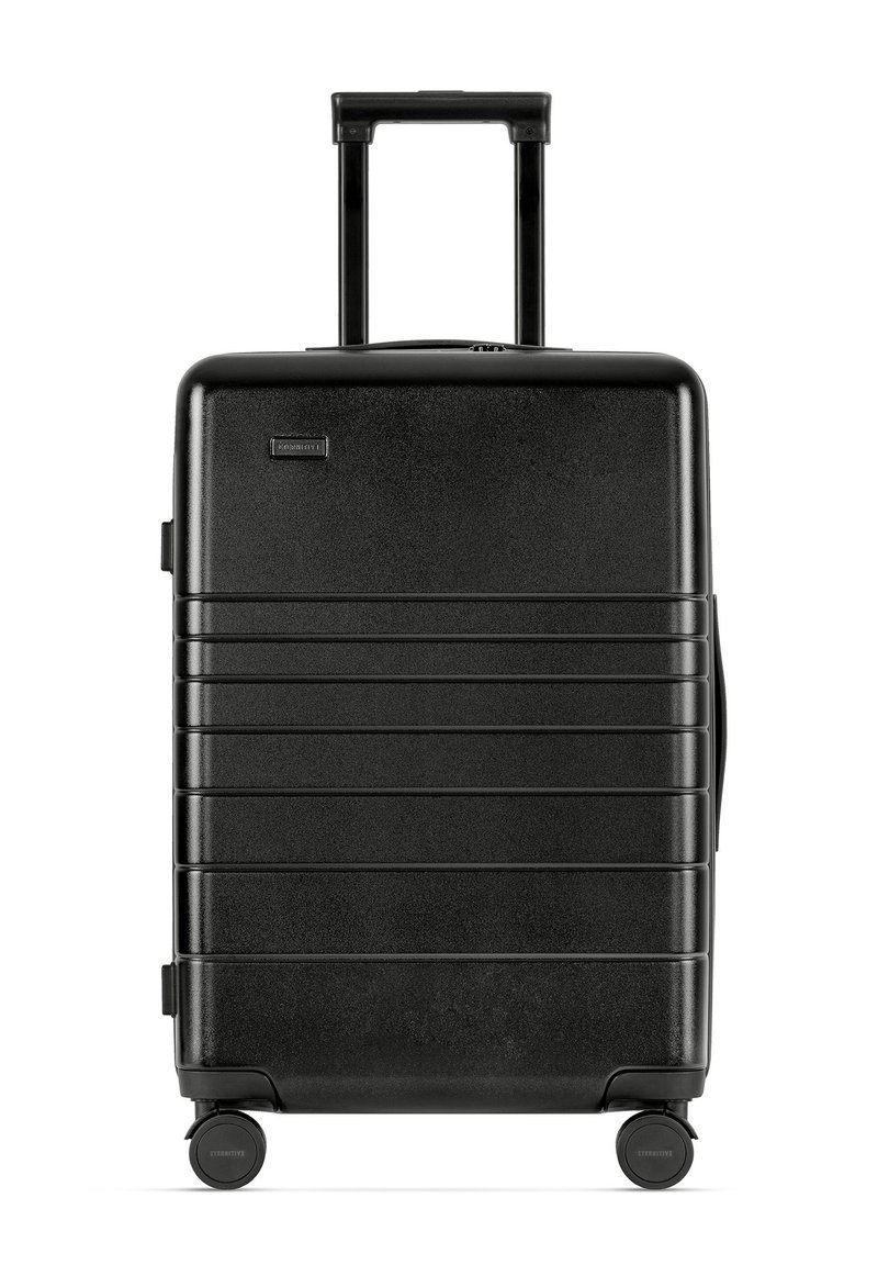 Black hard-shell suitcase with a textured finish, vertical grooves, retractable handle, and four wheels for mobility.