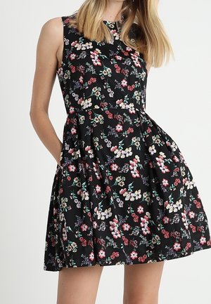 Vestito nero a fiori con scollo rotondo, senza maniche e gonna svasata con tasche. Decorato con motivi floreali colorati.