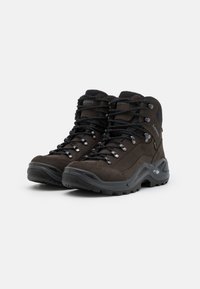 Braune Wanderschuhe aus Wildleder und synthetischen Materialien, robuste graue Gummisohlen, schwarze Schnürsenkel und Metallösen für einen sicheren Halt.