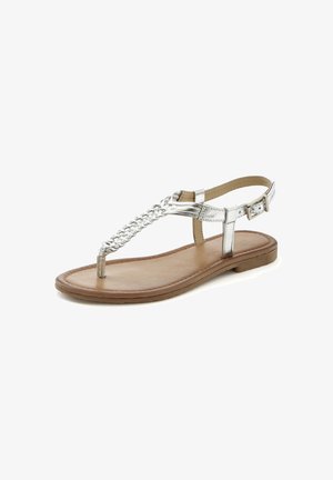 Silver metallic thong sandal with braided strap design, flat sole, adjustable ankle strap, and smooth brown insole.