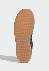 Suola della scarpa con fondo in gomma testurizzata, caratterizzata da un motivo a nido d'ape. Il lato mostra un design stampato floreale colorato sulla parte superiore in tessuto.