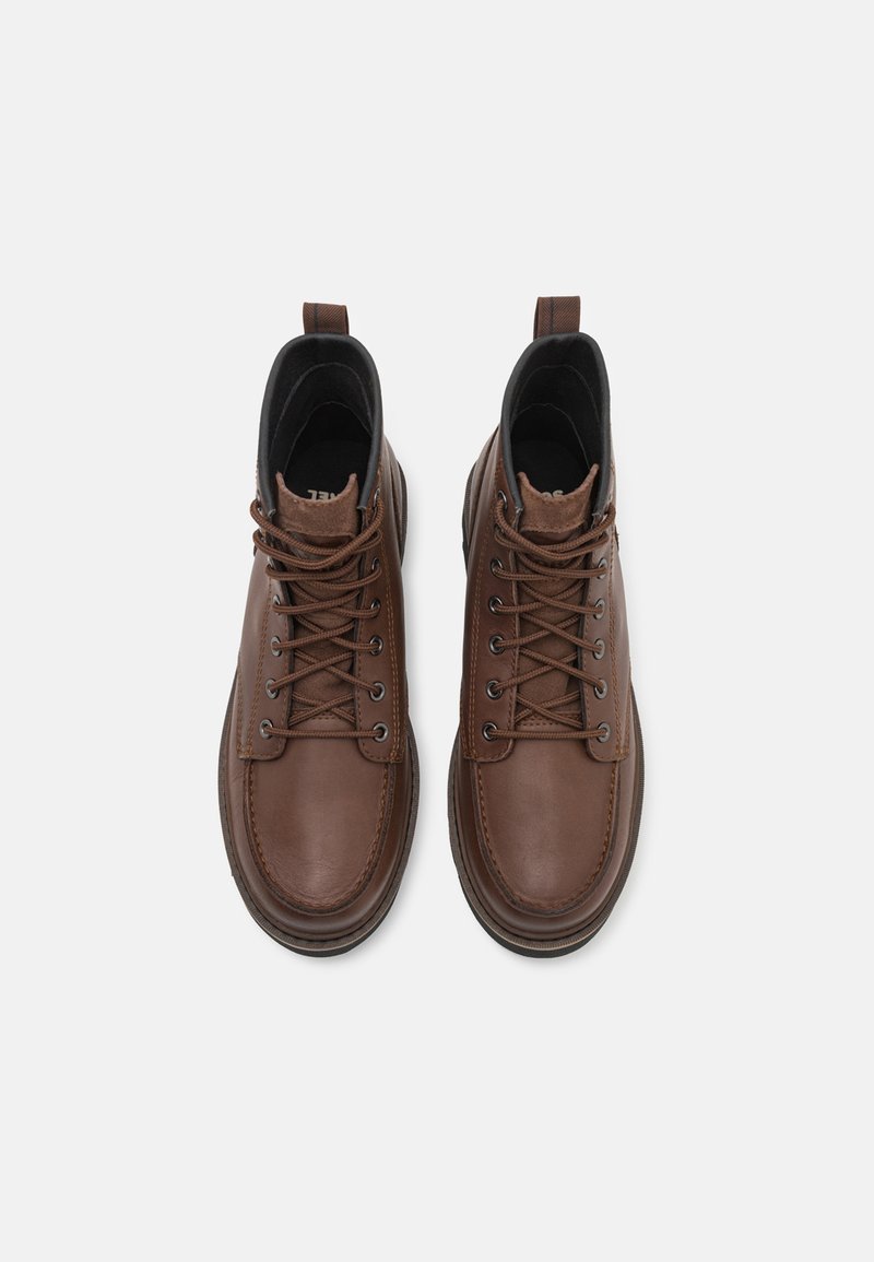 Bottines en cuir marron avec lacets, dotées d'un bout arrondi et d'une doublure en tissu doux, complétées par une semelle robuste et une languette.