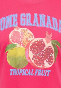 Tissu rose vif avec des grenades entières et coupées illustrées, des feuilles vertes, et un texte bleu « HOME GRANADA » et « TROPICAL FRUIT ».