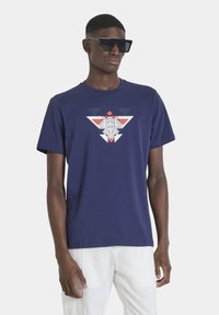 Navy blue cotton t-shirt featuring geometric graphic design in red, white, and gray. Short sleeves and crew neck style.