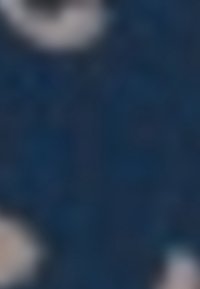 Une femme et une fille jouent aux échecs à une table en bois près d'une grande fenêtre avec des plantes en pot et des bouteilles d'eau à proximité.