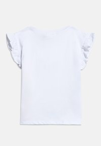 Λευκό πουκάμισο με κοντά μανίκια και βολάν στις άκρες, στρογγυλή λαιμόκοψη και ίσια στρίφωμα, απλωμένο επίπεδα σε ανοιχτό φόντο.