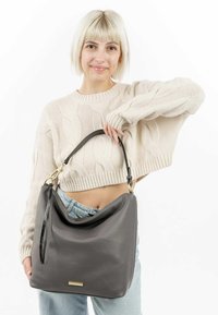 Grijze leren slouch tas met een zwarte band en gouden hardware. Gladde textuur, rechthoekige vorm met een gepolijste afwerking.