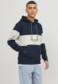 Sudadera con bloque de colores en náutico y gris claro, con un bolsillo frontal, capucha con cordón y logotipo bordado. Confeccionada en un suave tejido texturizado.