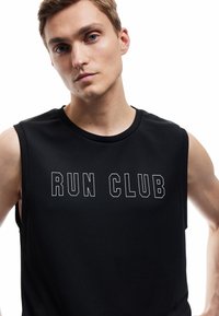 Zwarte mouwloze sporttop met "RUN CLUB" in vetgedrukte witte letters. De stof heeft een gladde, lichte textuur met een ronde hals.