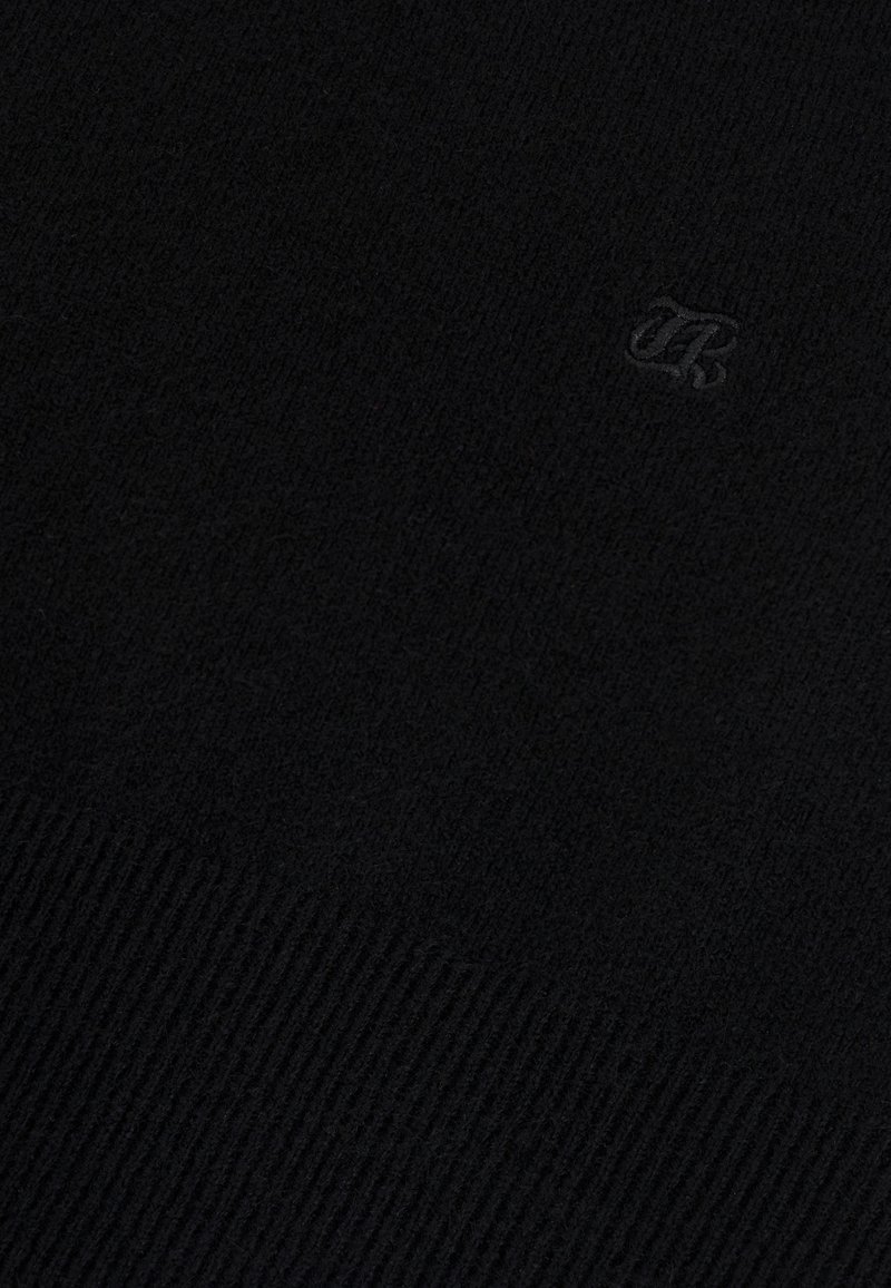 Black knitted sweater featuring a ribbed texture, with a subtle embroidered logo in the lower corner. Soft, warm material.
