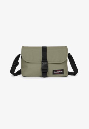 Borsa messenger Eastpak verde con chiusura a patta, fibbia nera, tracolla regolabile e patch con logo sulla parte anteriore. Tessuto dalla texture liscia.