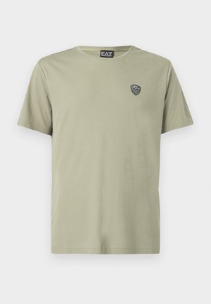 Light green T-shirt made of soft cotton, featuring a round neckline and short sleeves. Includes a small black logo patch on the chest.