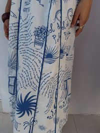 Fustă din material alb, cu ilustrații albastre de plante, ghivece și text scris de mână. Include o margine verticală albastră pe margini.